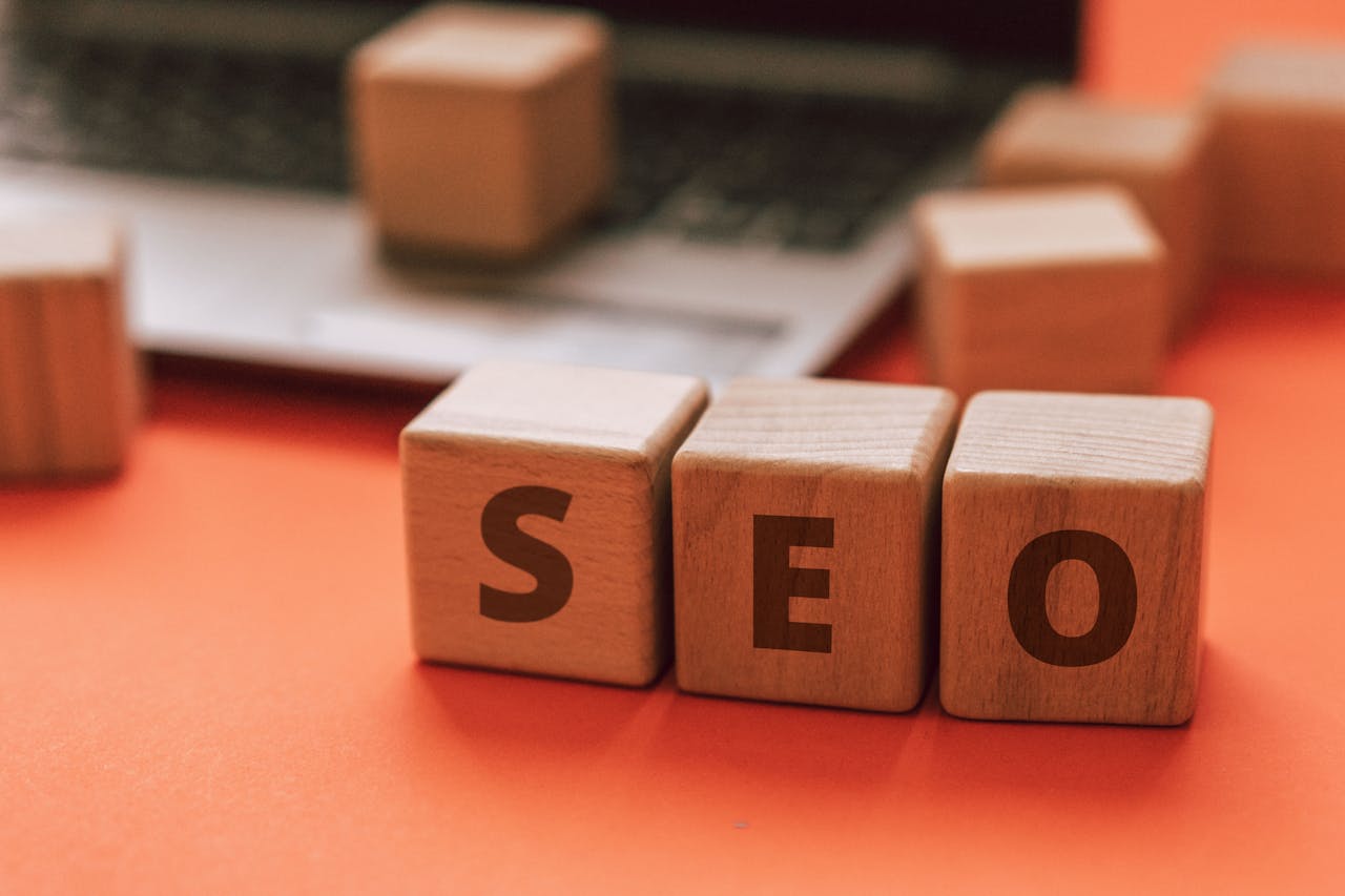 about-img-01 Wooden blocks spelling SEO on a laptop keyboard convey digital marketing concepts.